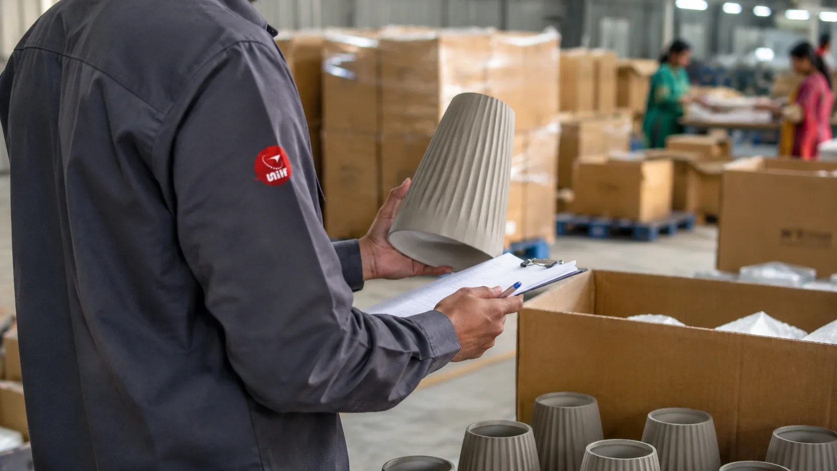 UTS inspector checking a product sample against the order files inside a factory warehouse