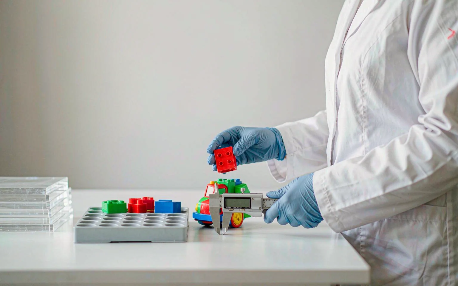 UTS technician measuring a molded plastic toy with a caliper