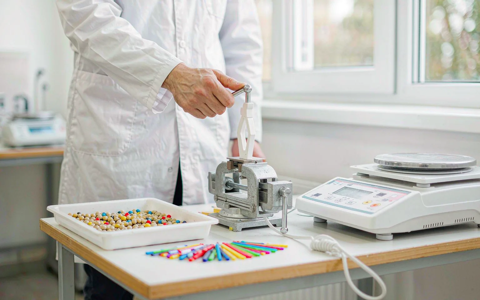UTS technician checking resin pellets, colour chips and plastic test specimens at a polymer testing bench