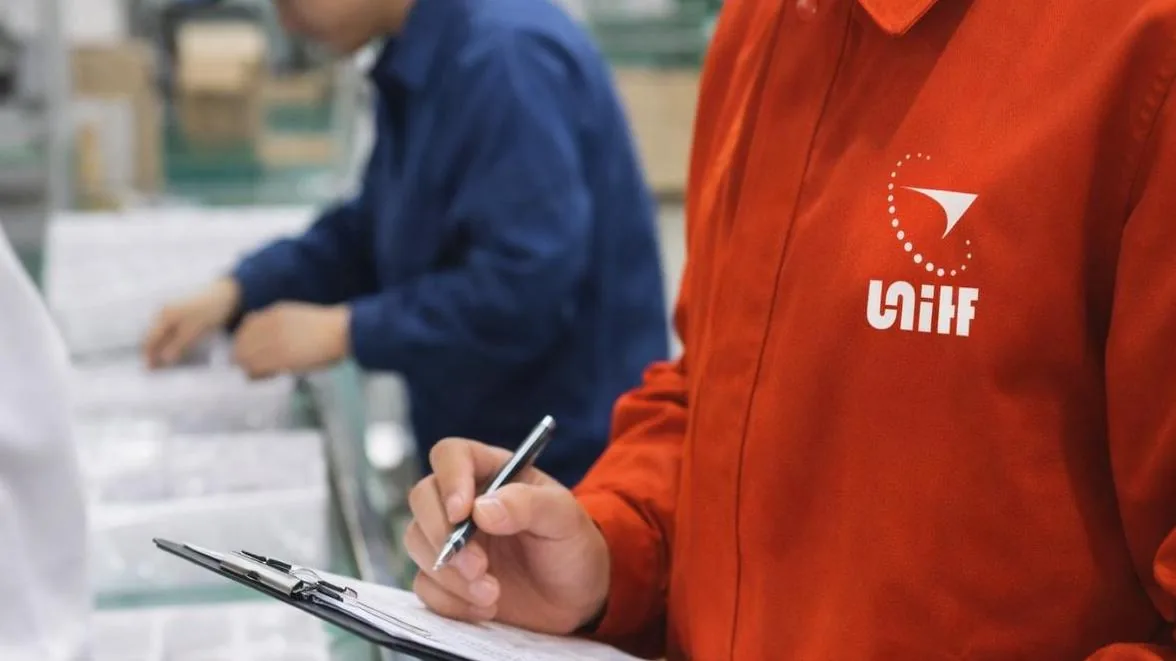 UTS inspector writing up inspection findings on a clipboard at the factory