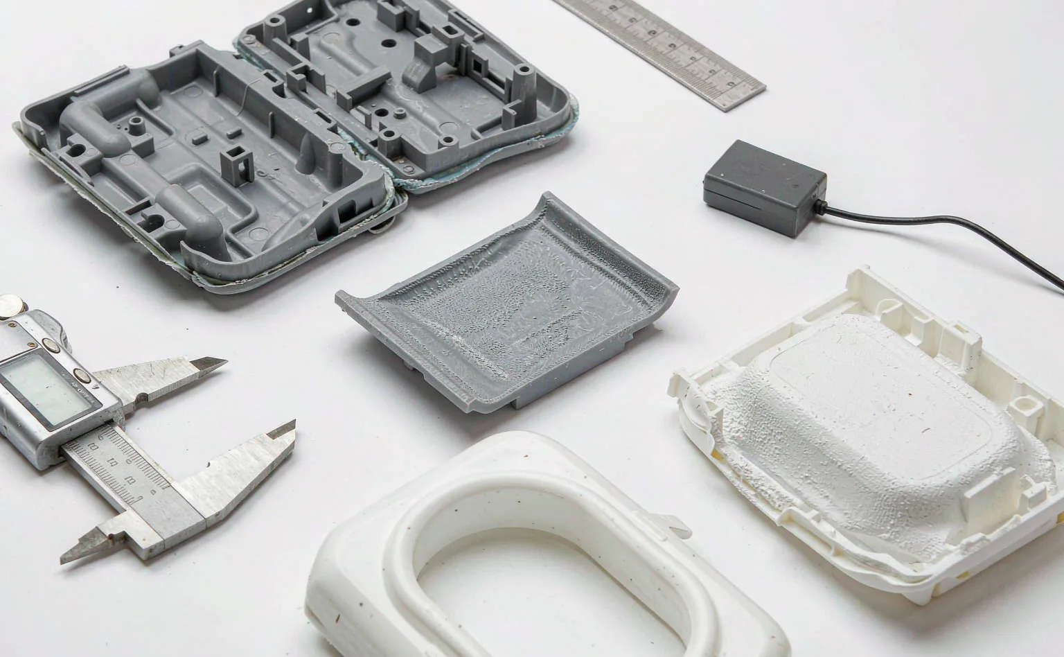 Rejected injection-molded parts showing surface defects and warpage on the inspection bench
