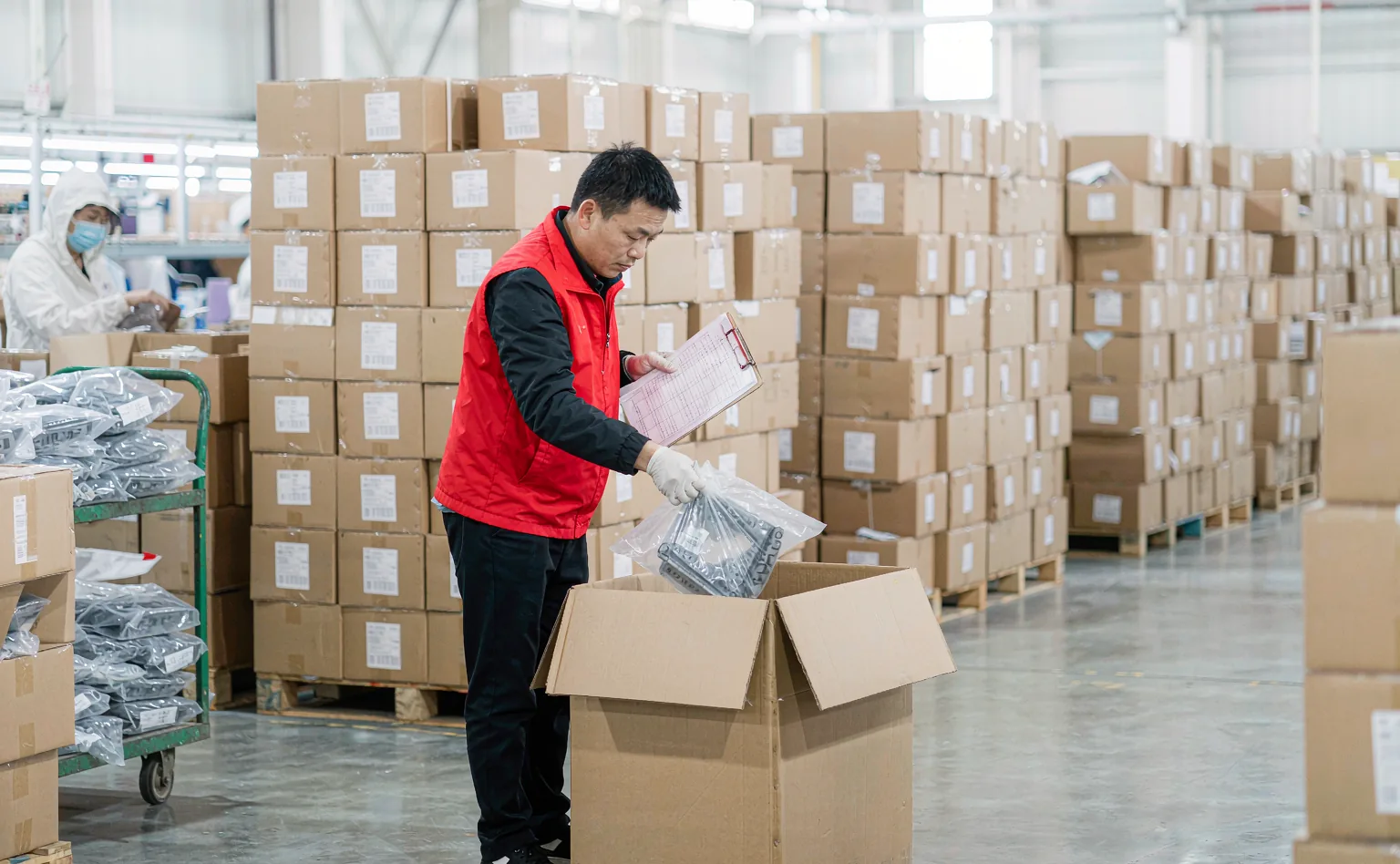 Inspector sampling bagged molded parts from packed cartons during a final random inspection